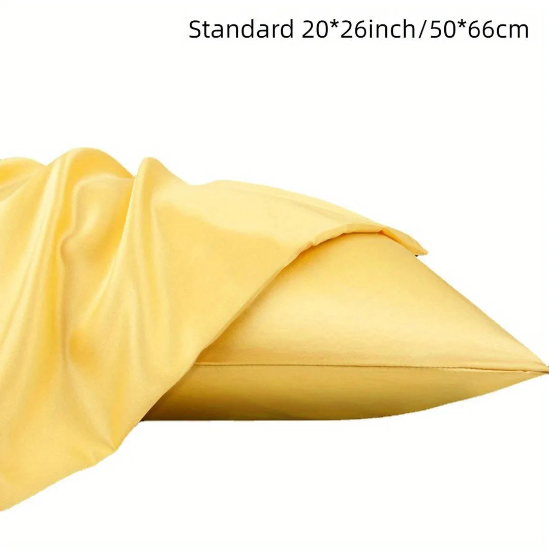 A pair of solid colour satin pillowcases in various shades on a bed.