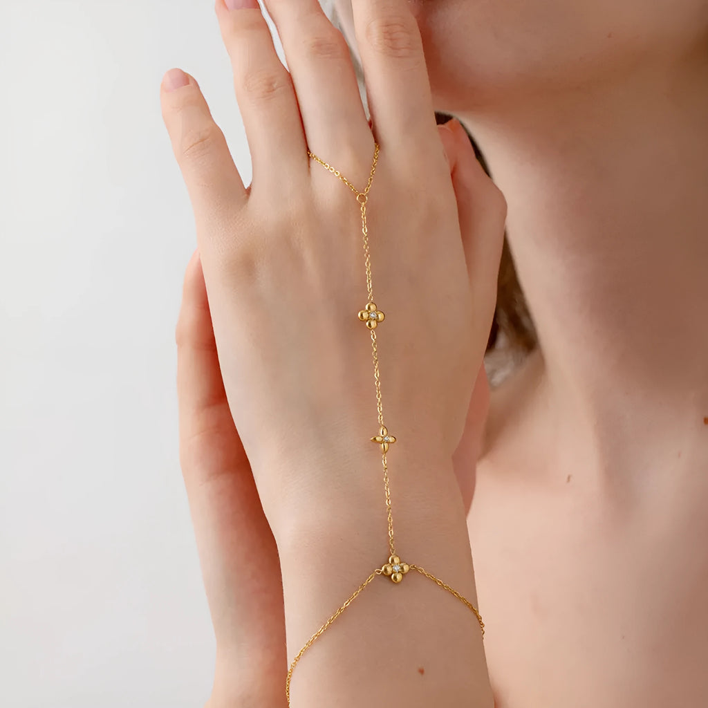Gold stainless steel women's bracelet with geometric design showing floral patterns and eight-pointed star charms