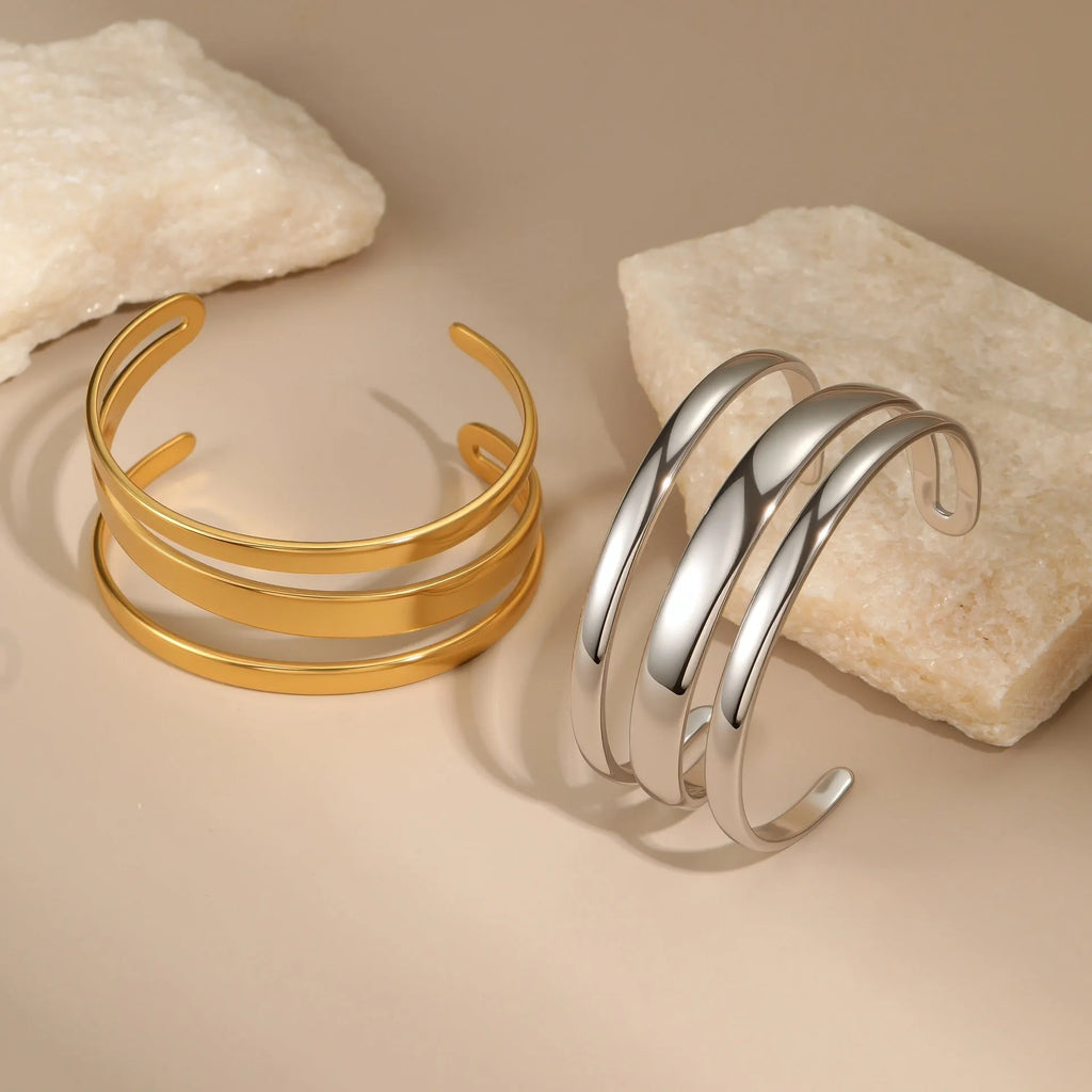 Stainless steel women's bracelet with geometric line design, shown in gold and steel finish options
