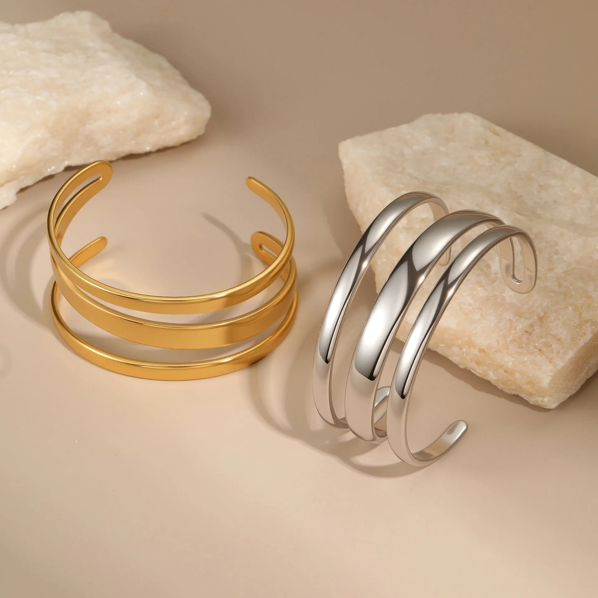 Stainless steel women's bracelet with geometric line design, shown in gold and steel finish options