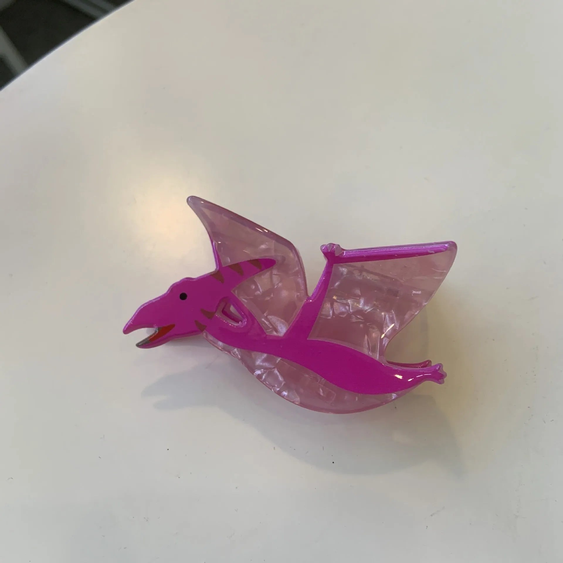 Dinosaur-themed acrylic jaw hair clip showing six colour variations with grip mechanism