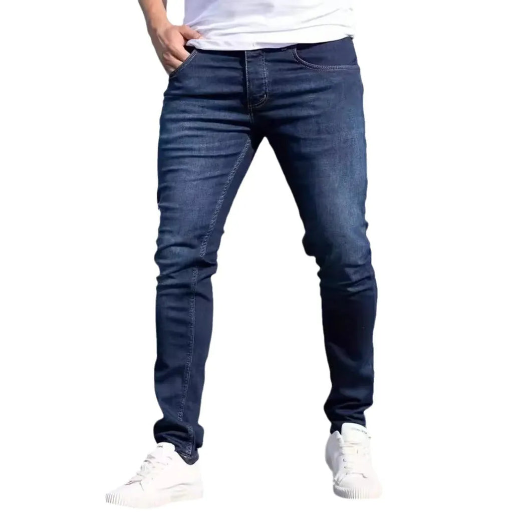 Man wearing dark blue slim-fit stretch cotton jeans with a skinny leg style.