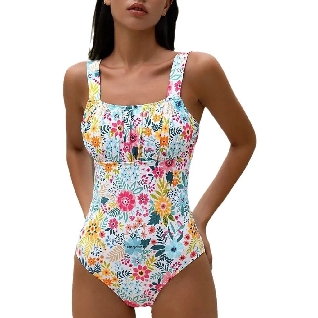 Women's floral print one-piece swimsuit on hanger showing full-bed design and polyester fabric