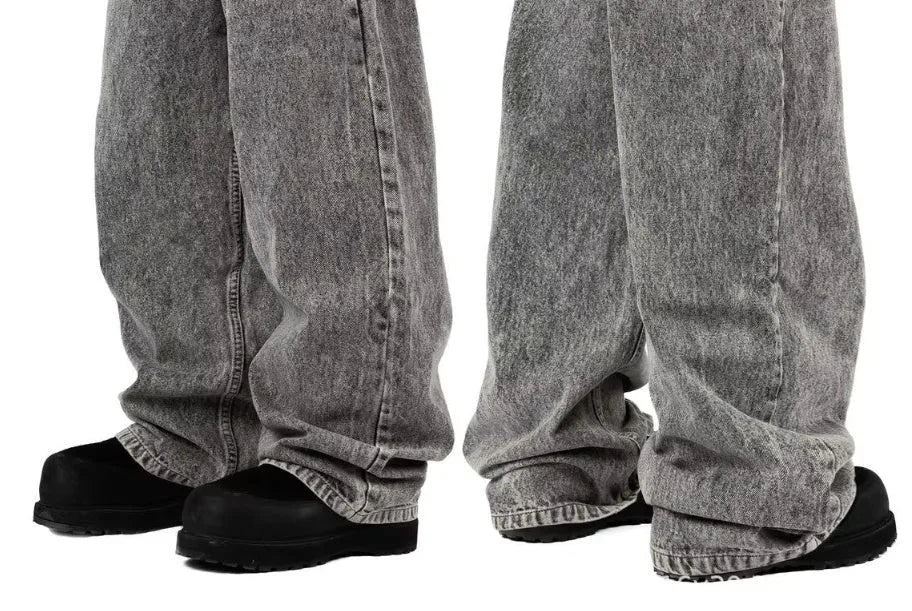 Grey loose straight-leg denim trousers on hanger showing mid-waist design and cotton fabric texture