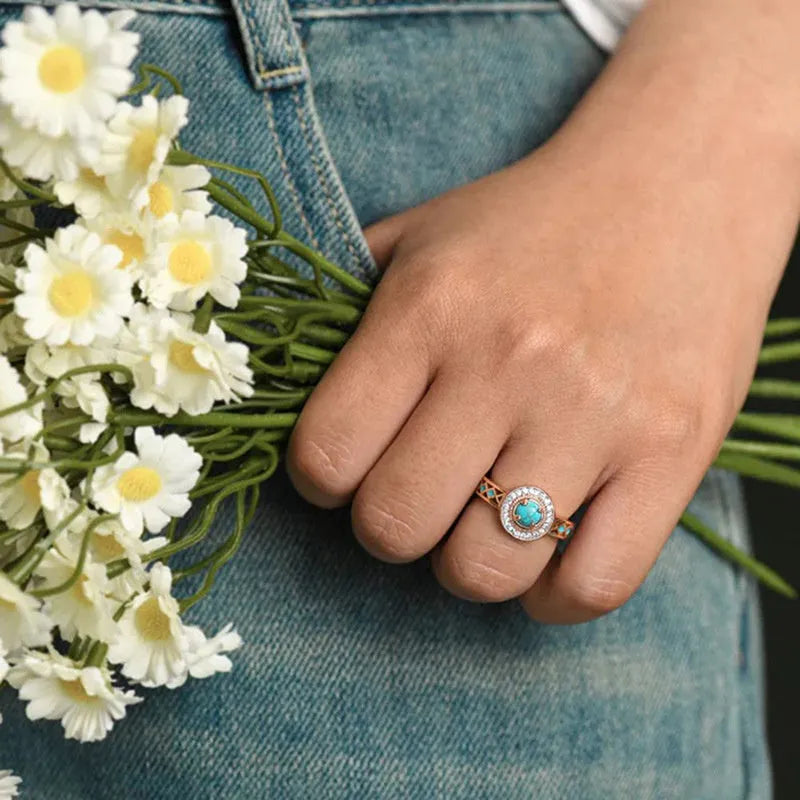 Rose gold geometric women's ring with turquoise inlaid zircon on a copper band.