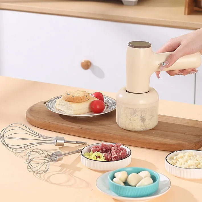 Beige electric garlic chopper with USB charging cable, 250ml cup, and stainless steel blade on kitchen counter