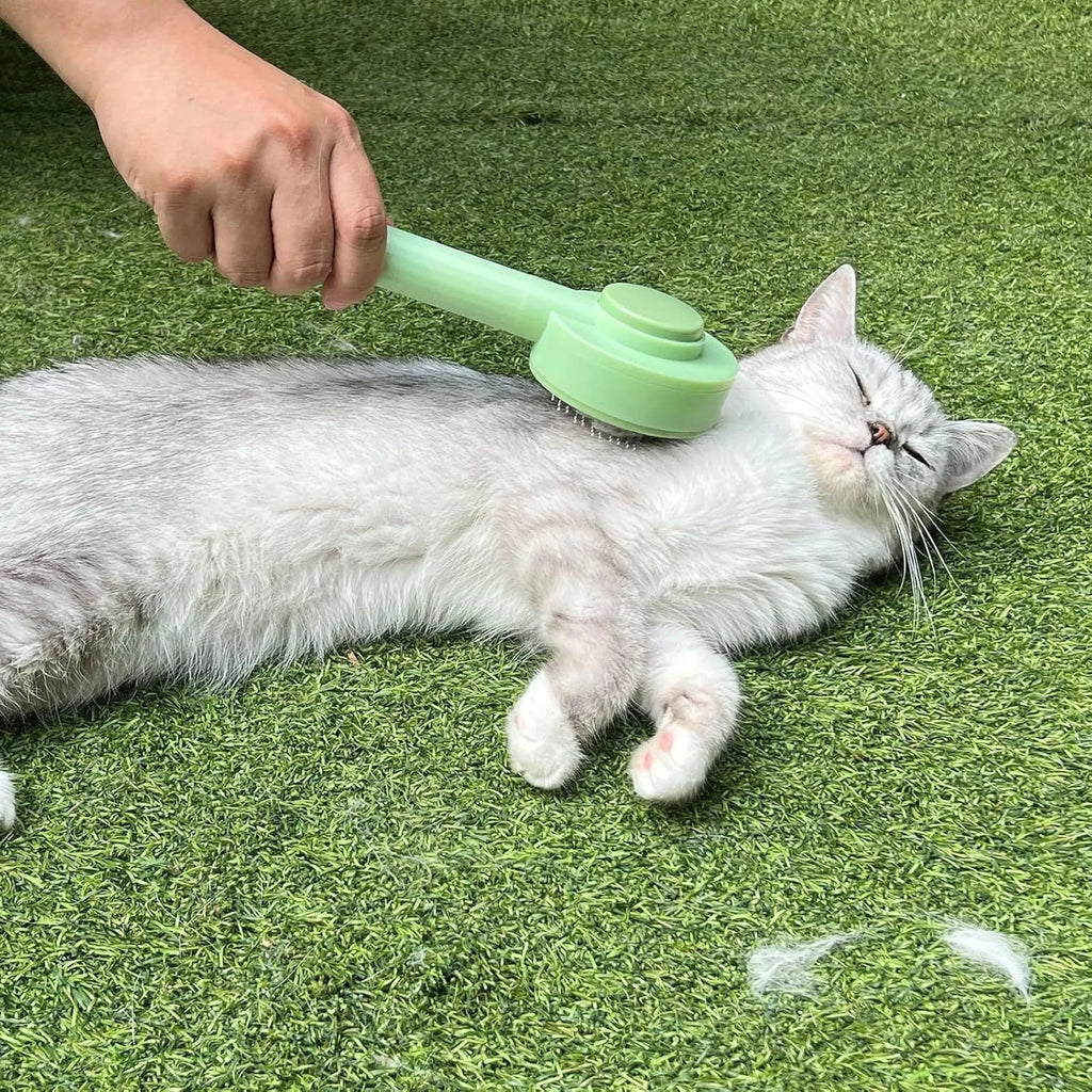 Green and yellow 2-in-1 pet grooming brush with stainless steel teeth and hanging loop.
