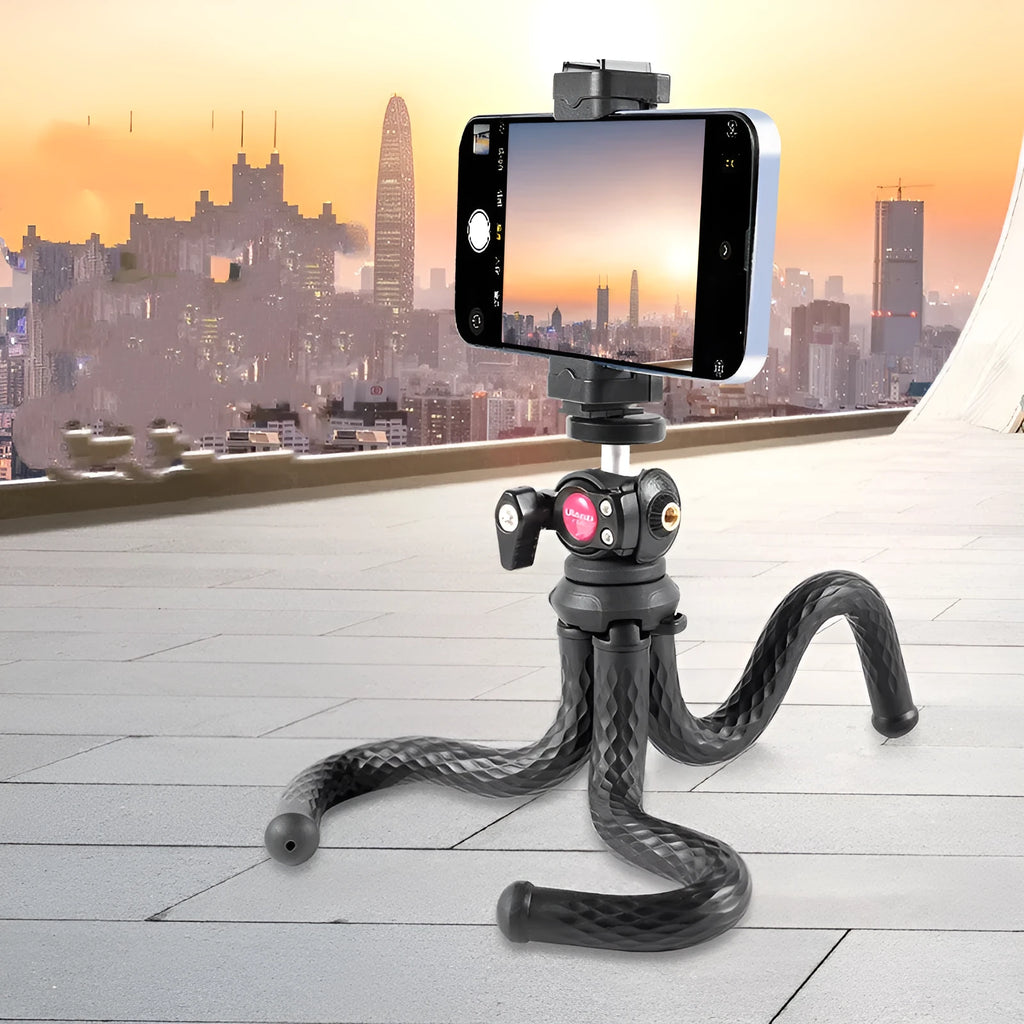 Black octopus leg mobile phone tripod with clip, extended to 360mm on a table.