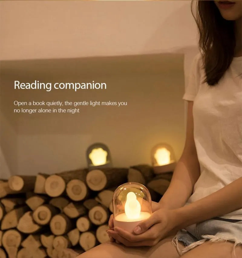 Grey cat paw shaped USB night light with rotating soft light and music box function on wooden desk