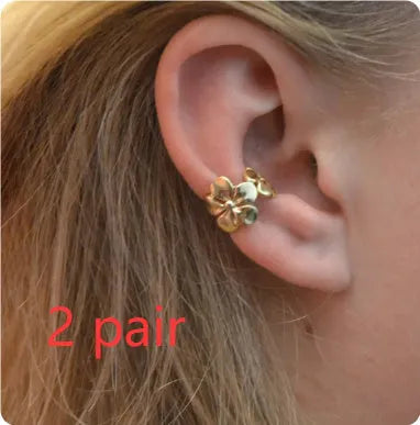 Gold starfish and conch shell earrings for women on a white background.