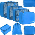 Set of eight cubic-shaped travel packing bags in assorted colours including beige, black, pink, and leopard print patterns.