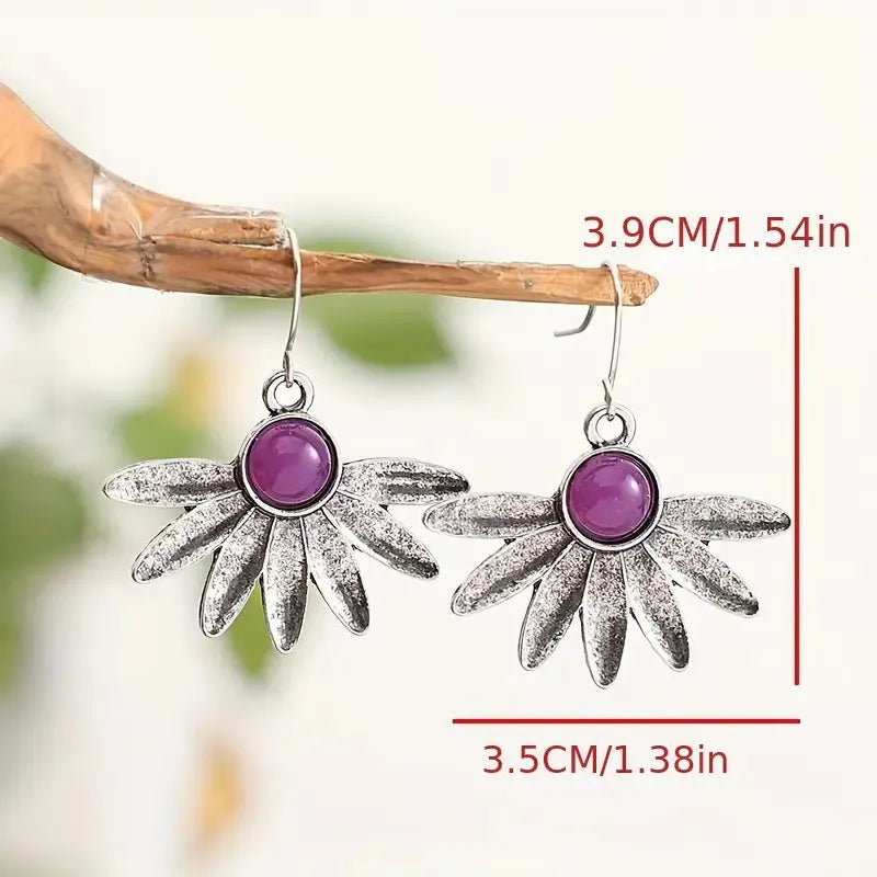 Close-up of purple bohemian drop earrings with animal zodiac design and resin gemstone details on alloy posts.