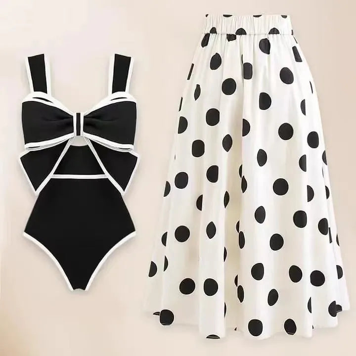 Women's black one-piece swimsuit with a white round skirt and a central bow detail.