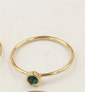 DIY knuckle ring craft kit showing 14K gold-plated ring base and green, blue, dark red, and white zircon accents.