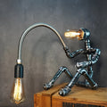 American industrial retro style desk lamp with a dark iron shade on a wooden table.