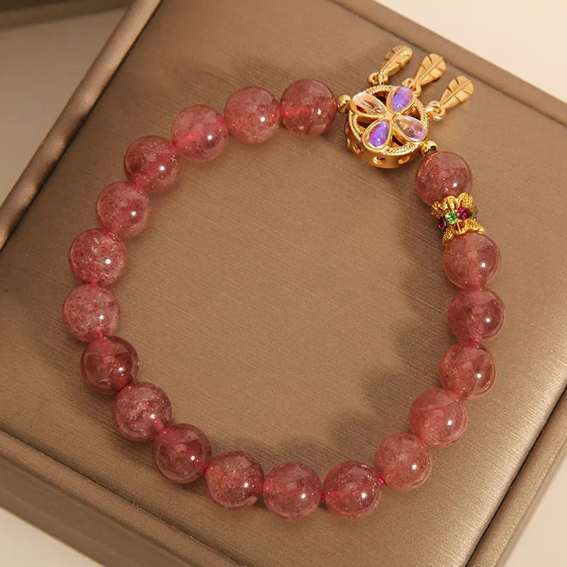 Women's Strawberry Quartz crystal bracelet with a four leaf clover dream catcher ball pendant.