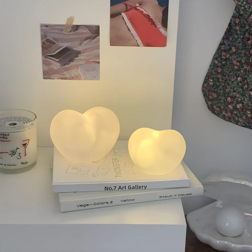 Pink and white vinyl atmosphere desk lamps in small and large sizes with warm LED glow.