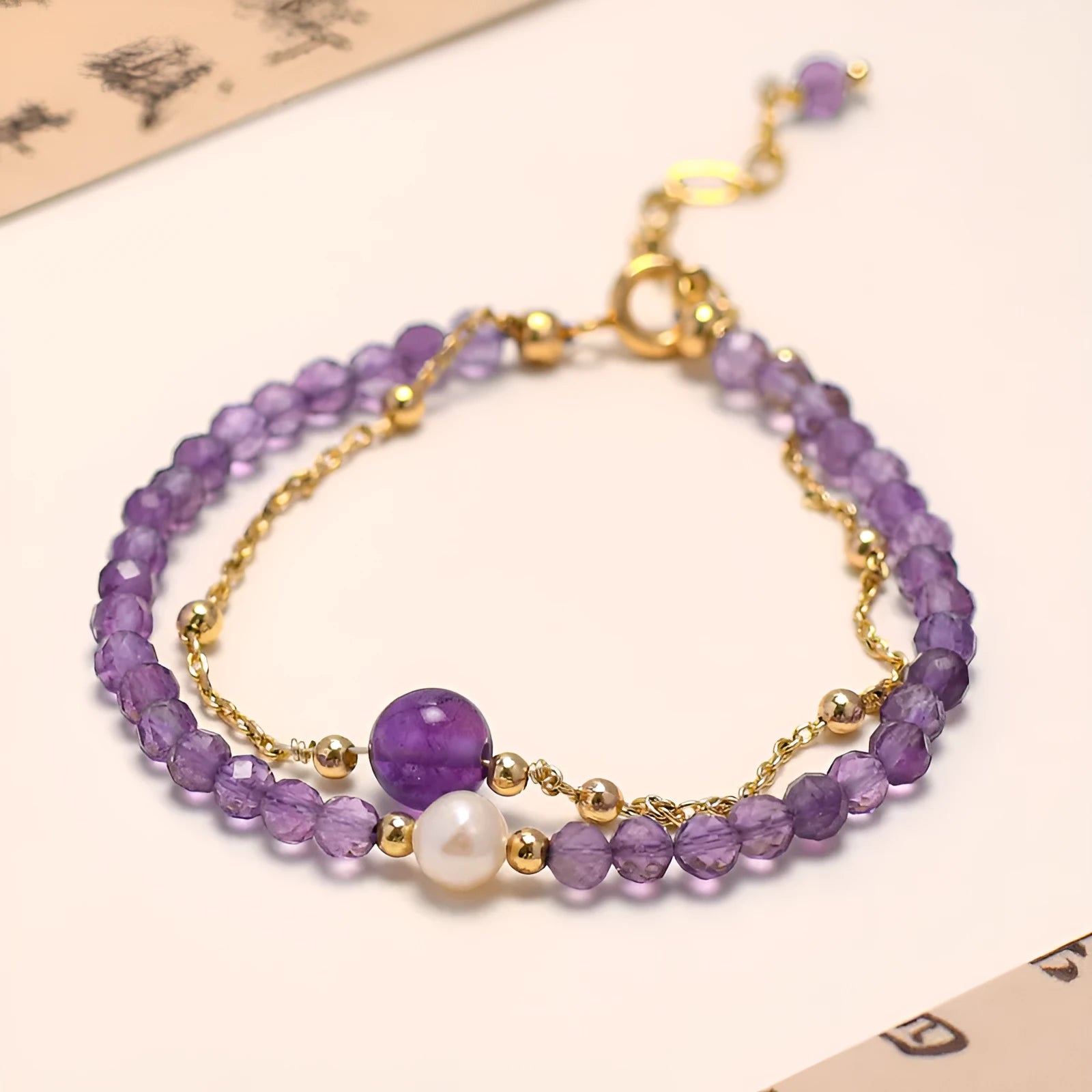 Chinese style women's bracelet with electroplated metal and amethyst crystal stones cut in diamond shapes.