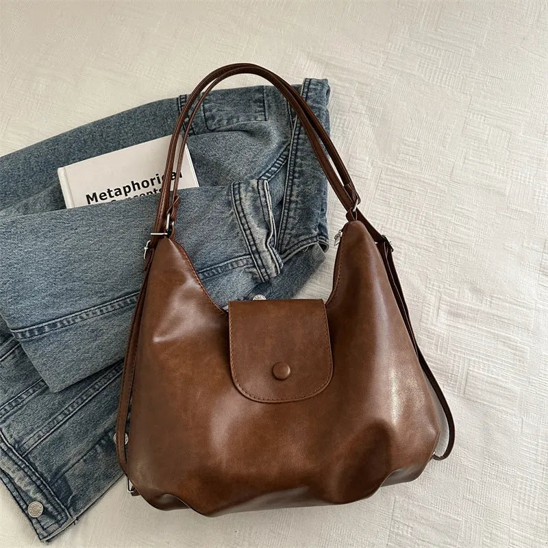 Textured PU leather commuter shoulder backpack in horizontal square shape with single strap and mobile phone compartment