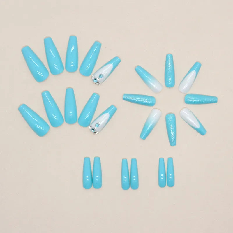 Long ballet shape false nails with solid blue colour and smart blue diamond design, shown with adhesive glue.