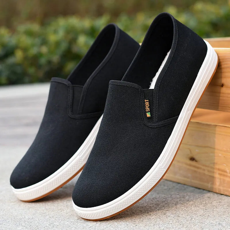Men's low-top canvas slip-on shoes in black and blue colours showing round toe and composite sole