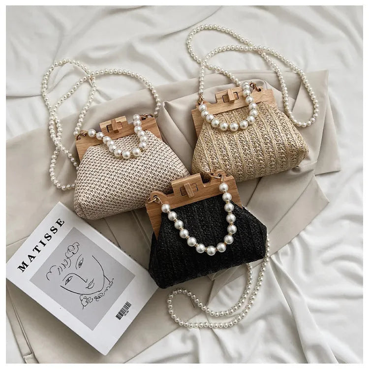 Women's straw woven shoulder bag with pearl chain detail showing interior organisation compartments