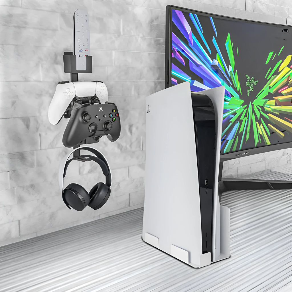 White wall-mounted plastic hook holding a black game controller and TV remote.