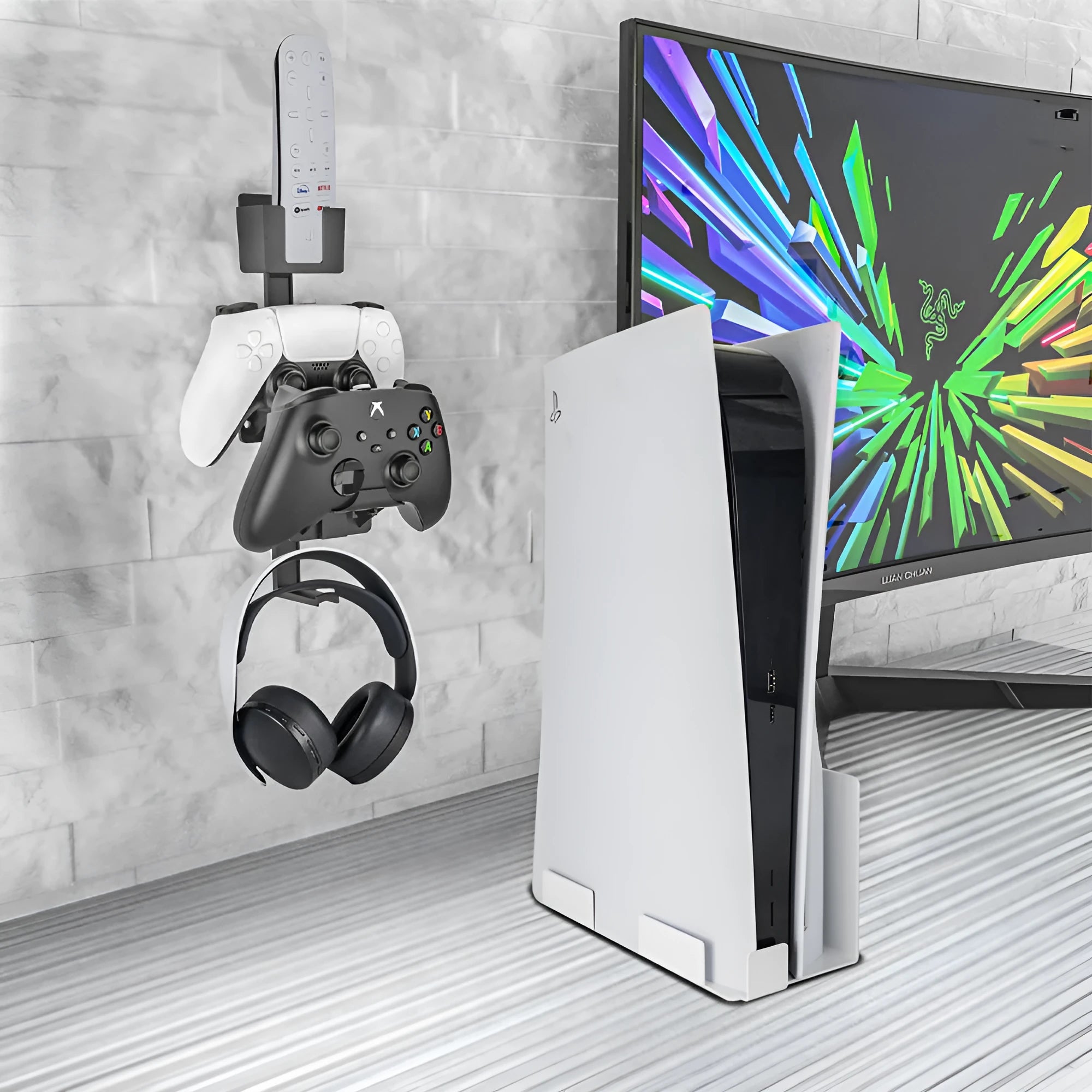 White wall-mounted plastic hook holding a black game controller and TV remote.