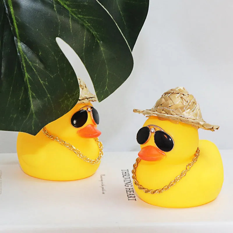 Cartoon yellow duck car ornament wearing a straw hat and sunglasses