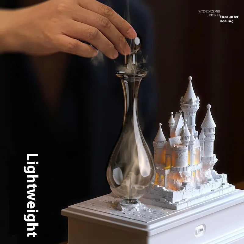 White medieval castle-shaped waterless aromatherapy machine with ambient light on a table.