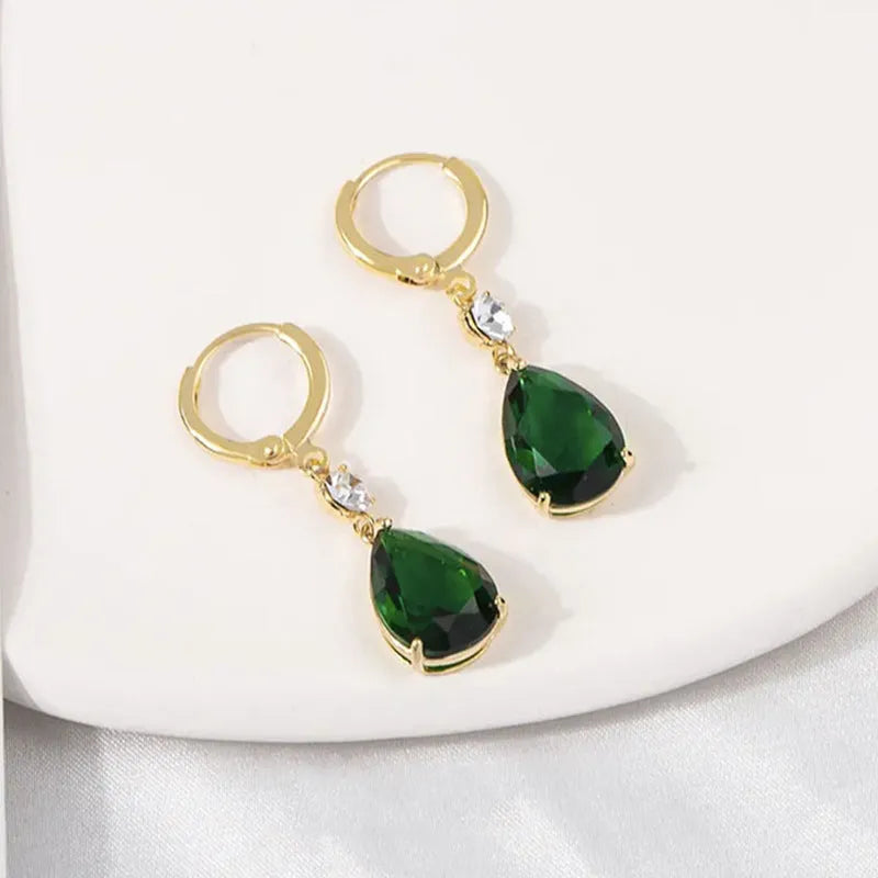 Geometric green teardrop alloy earrings on a plain background