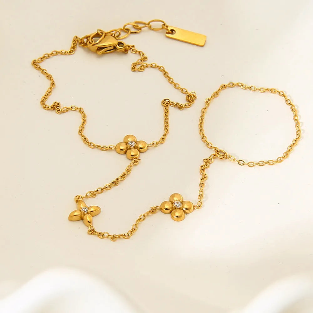 Gold stainless steel women's bracelet with geometric design showing floral patterns and eight-pointed star charms