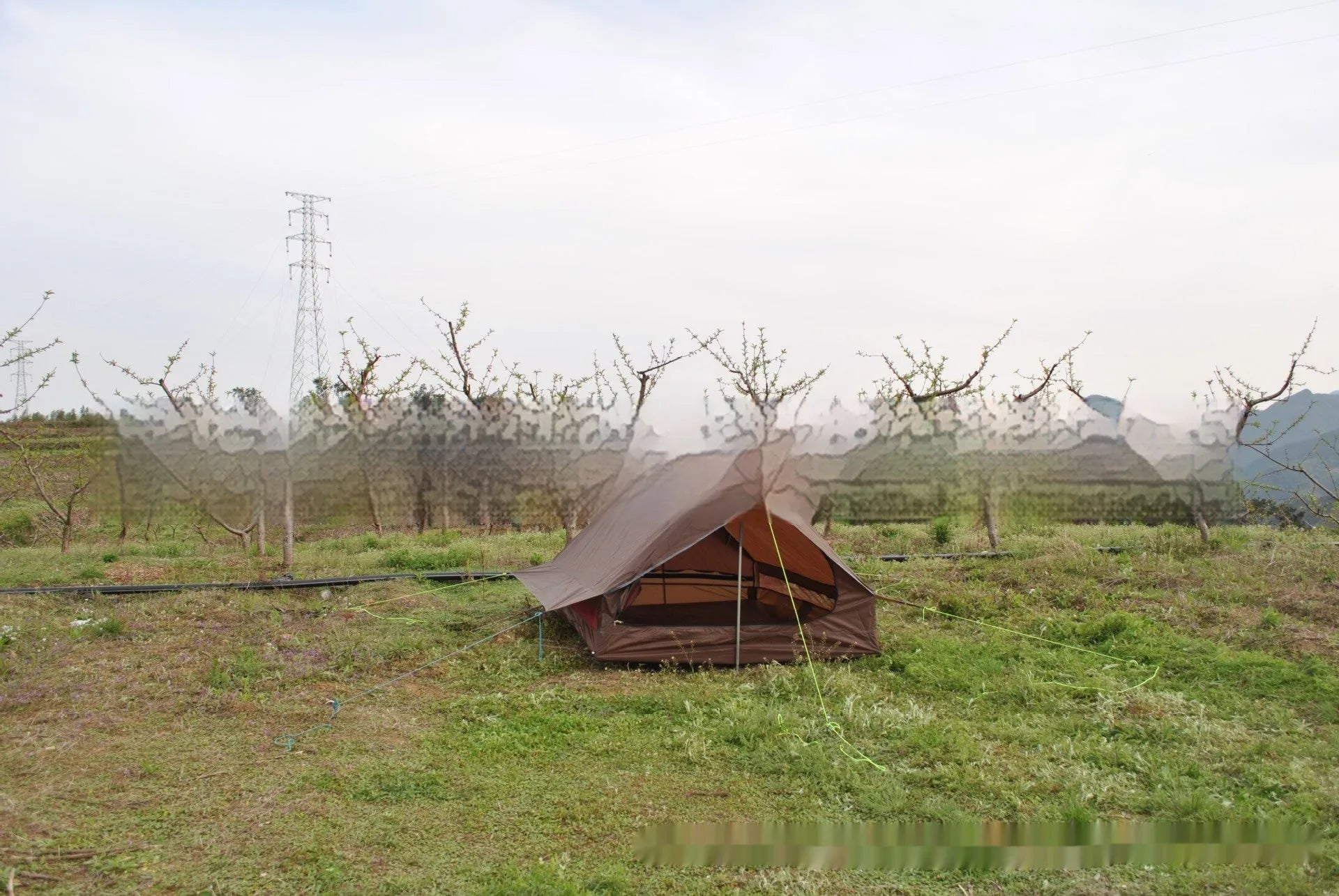 Brown or white A-frame pole-free cabin tent erected with hiking cane supports