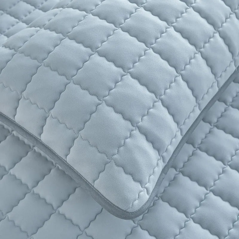 Blue washed cotton waterproof fitted sheet with elasticated edges on mattress.