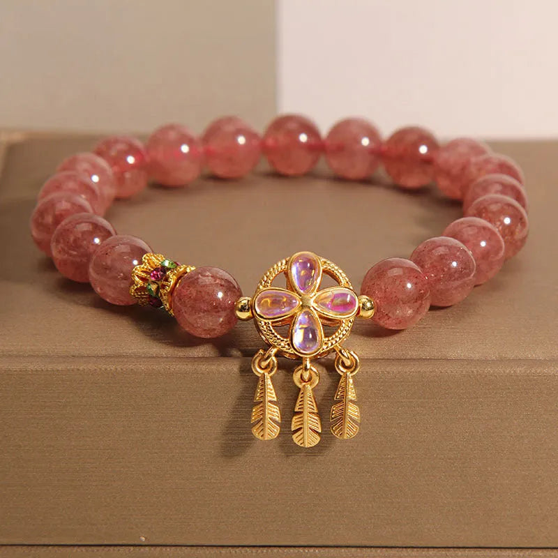 Women's Strawberry Quartz crystal bracelet with a four leaf clover dream catcher ball pendant.