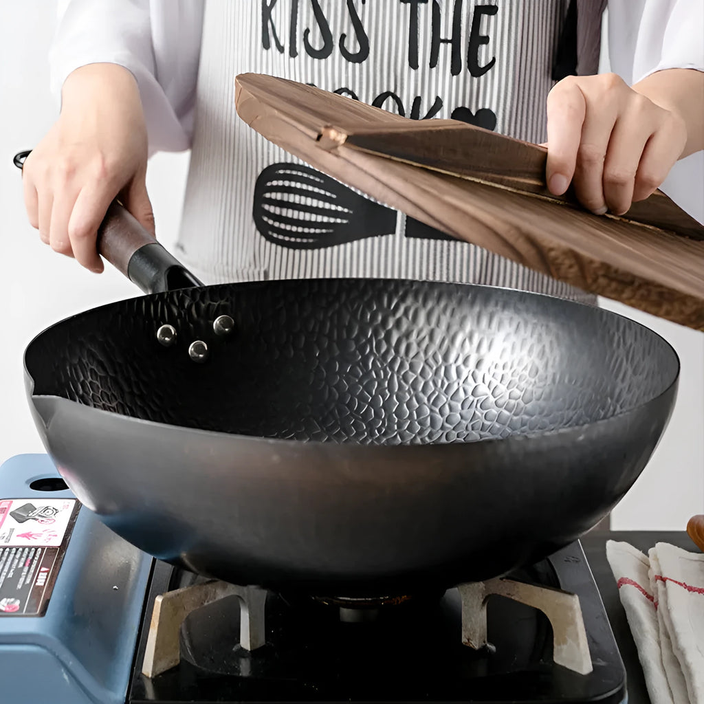 Traditional black iron wok with long wooden handle measuring 32cm diameter