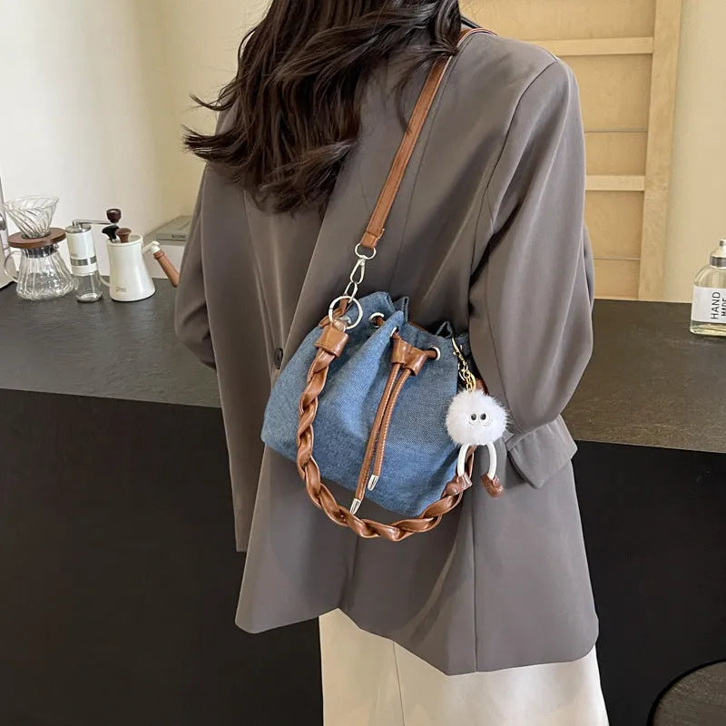 Blue synthetic leather cross body bucket bag with sandwich pocket and sling strap