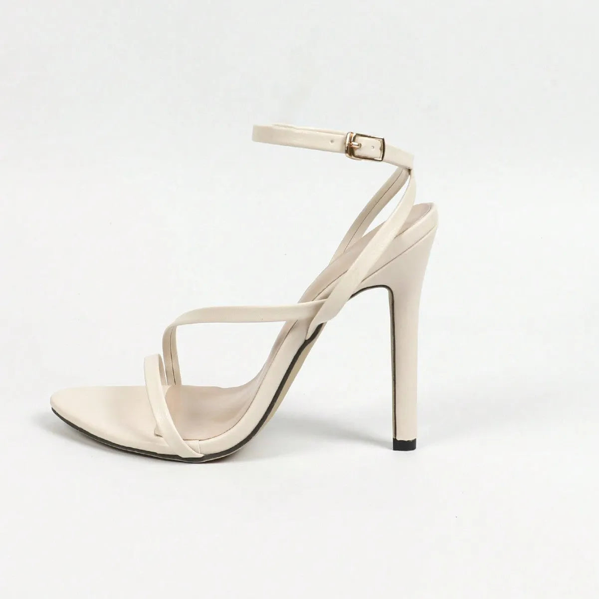 Women's gold heeled sandals with a cross ankle strap and round open toe on a white background.