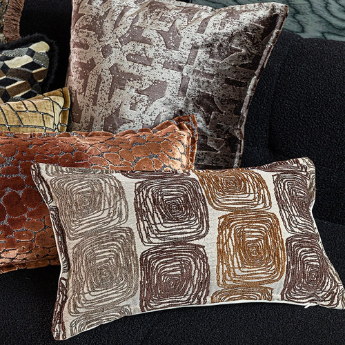 Cream and coffee-coloured abstract coil pattern on two pillow covers: one square, one rectangular.