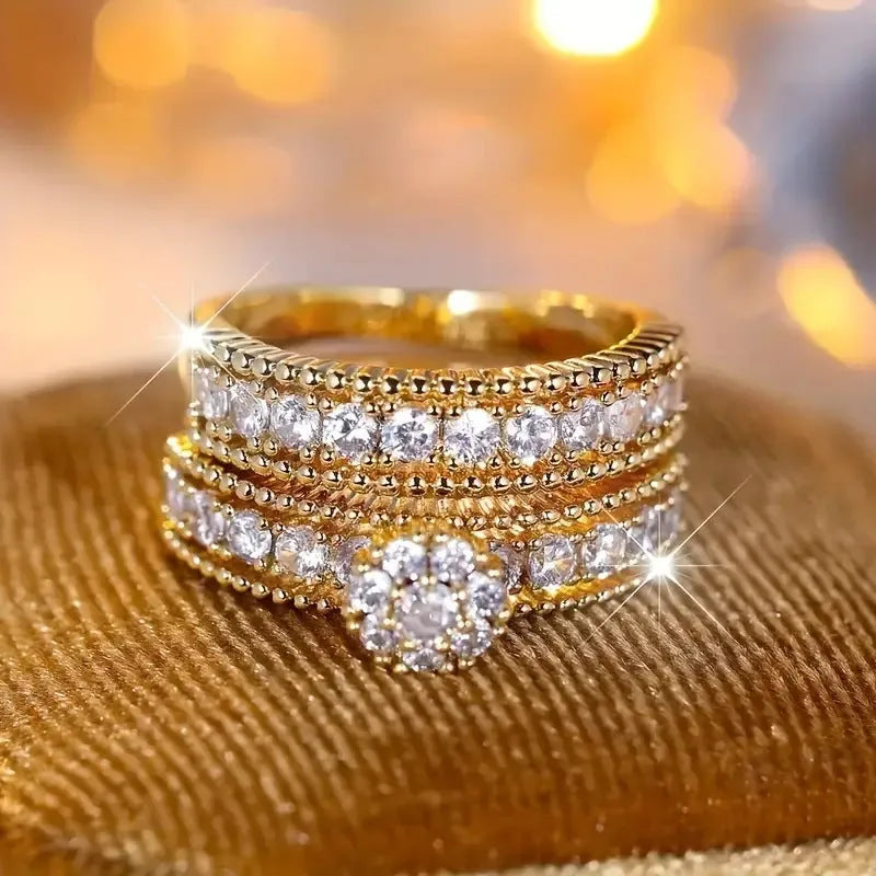 Two geometric gold electroplated zinc alloy rings on a flat surface