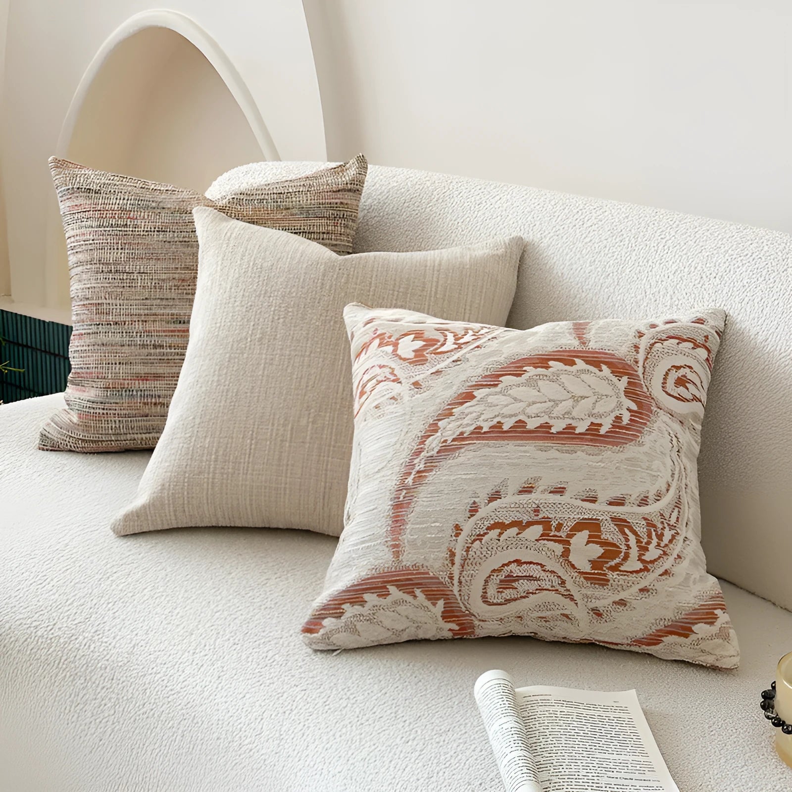 Amber paisley patterned jacquard sofa cushion cover on a sofa, showing textured fabric and plant motif.