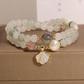Women's crystal bracelet with a carved jade shell ginkgo leaf pendant on a gold-plated setting.