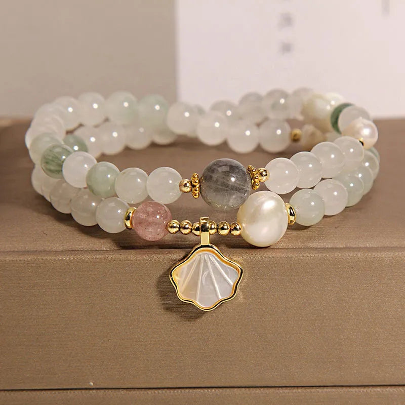 Women's crystal bracelet with a carved jade shell ginkgo leaf pendant on a gold-plated setting.