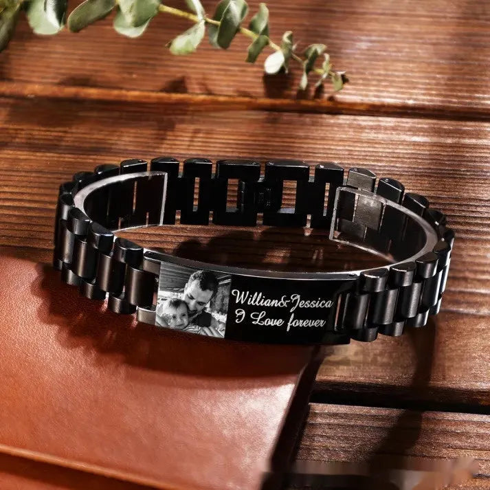 Titanium steel men's bracelet with curved heart shape and black lettering on a grey background.