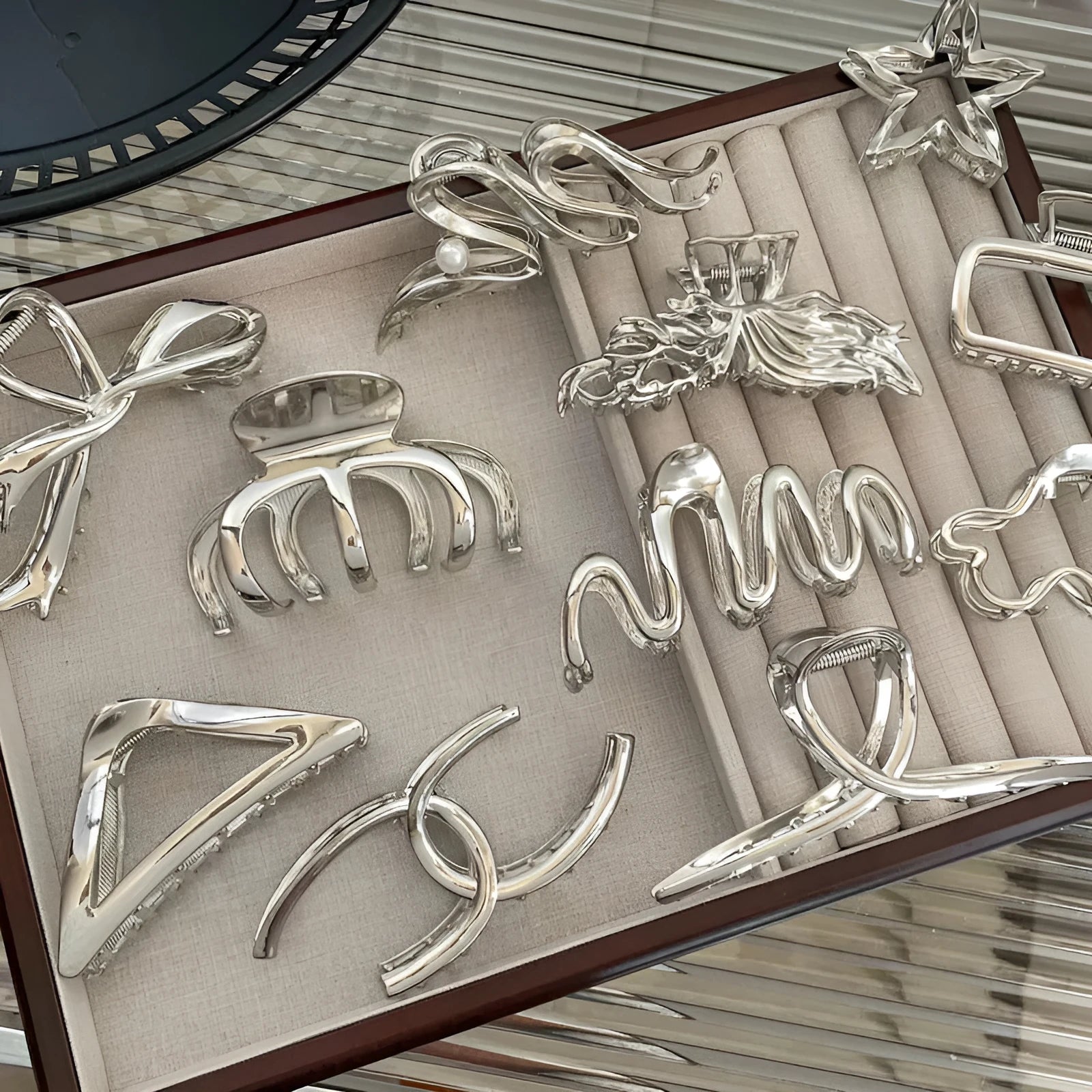 Electroplated silver metal hair barrettes in various designs including cross, wave, and bow shapes.