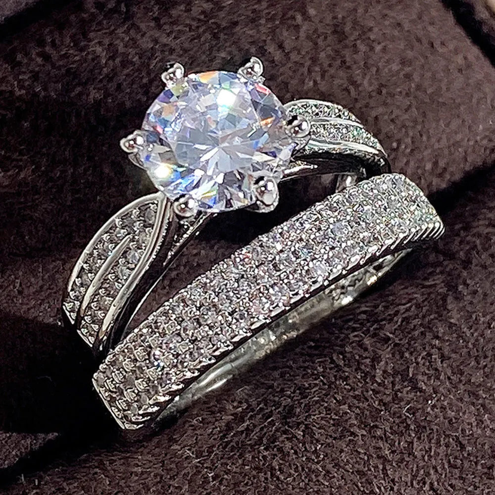 White gold colour geometric alloy ring bracelet with round design elements on a plain background.