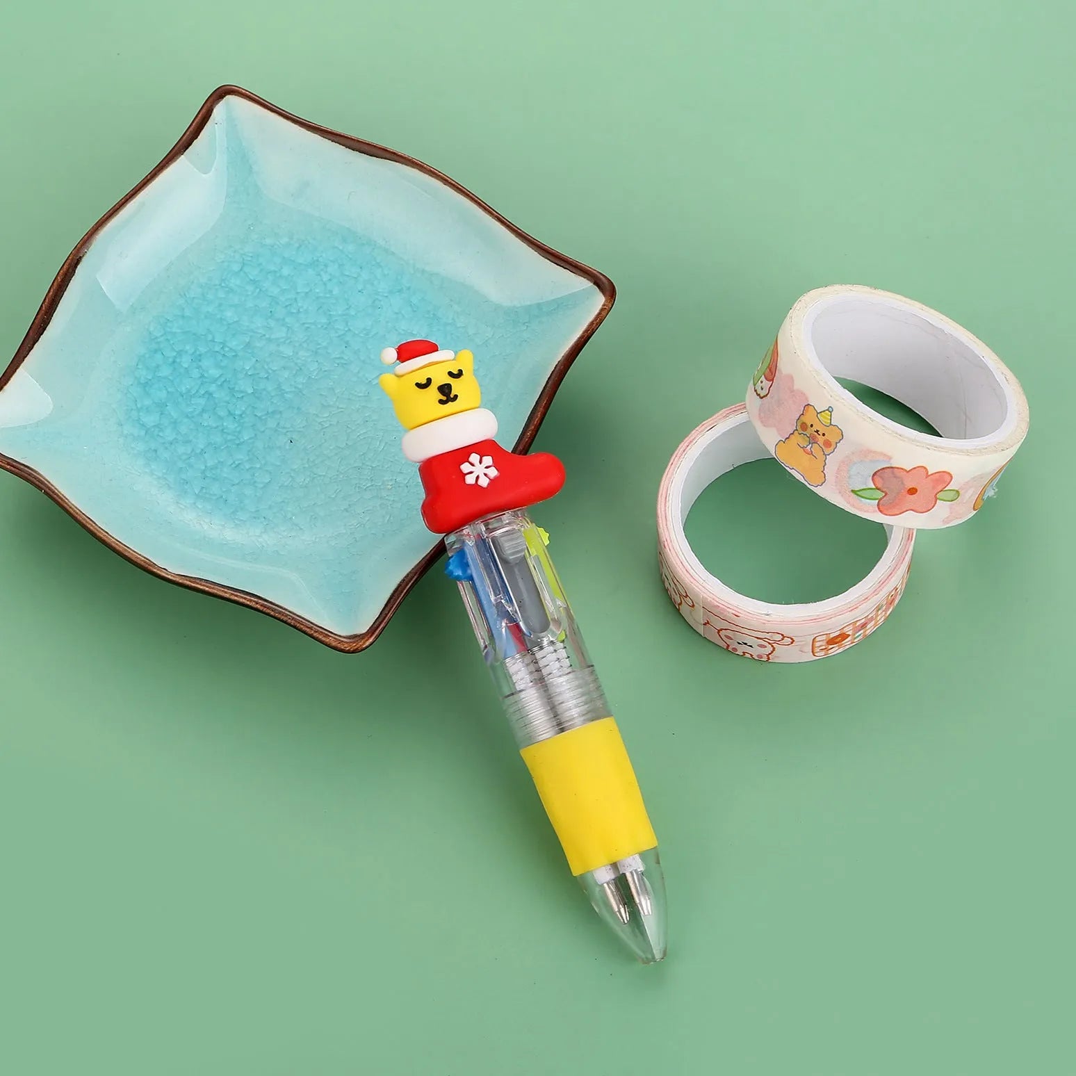 Christmas mini four-colour press-type ballpoint pen showing festive designs, 11cm long.