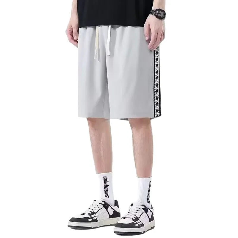 Men's loose-fit grey track pants with an elasticated waist on a neutral background.