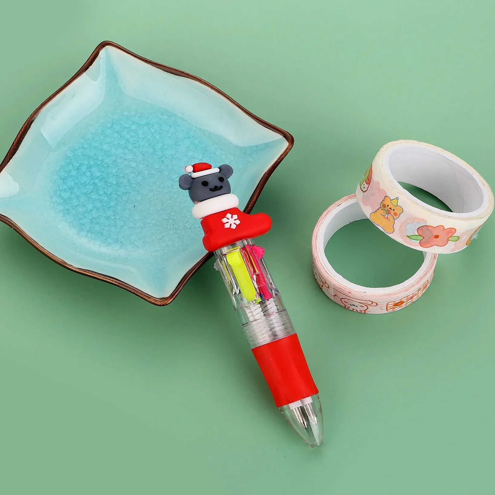 Christmas mini four-colour press-type ballpoint pen showing festive designs, 11cm long.