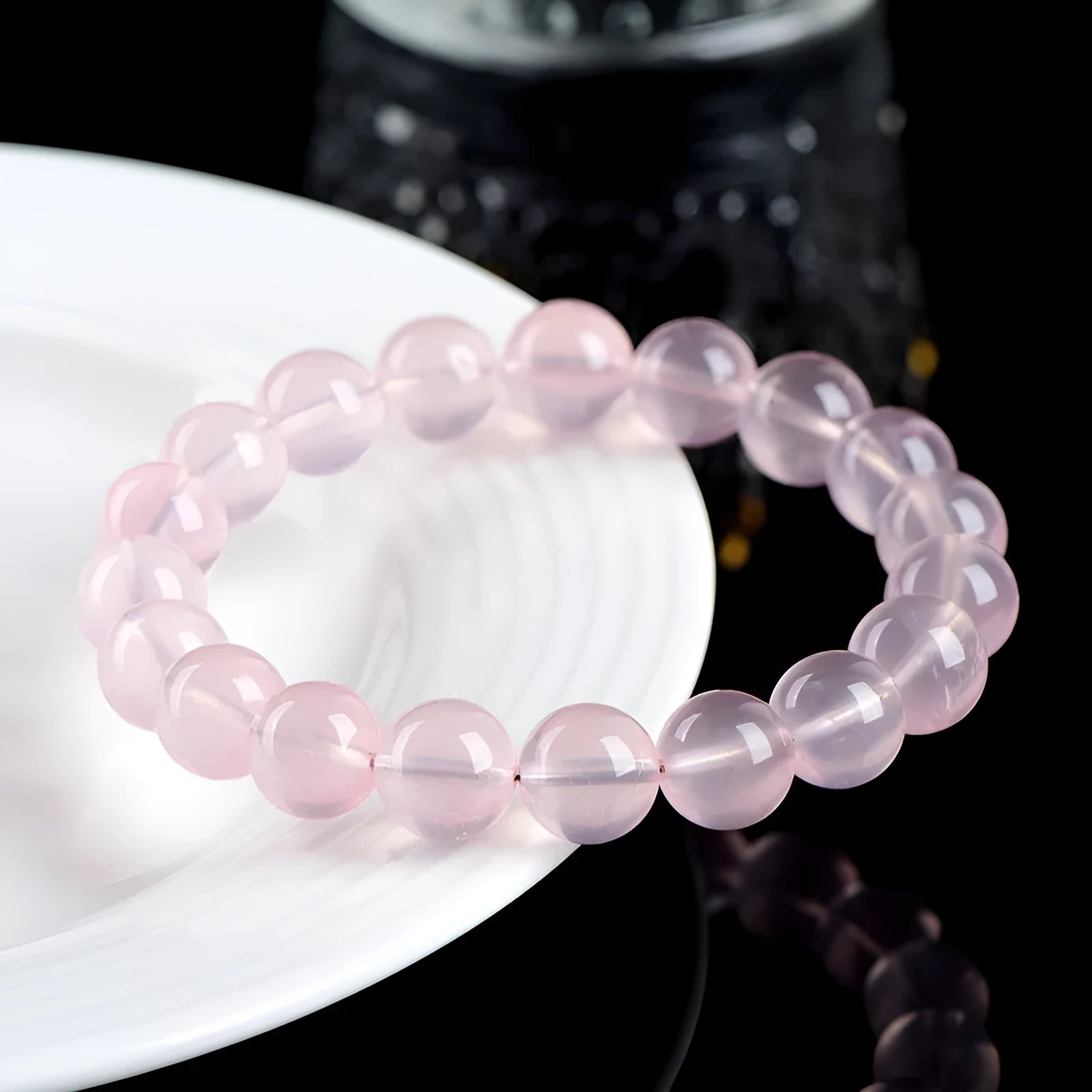 A polished natural starlight crystal bead bracelet in pink, shown as a single circle.
